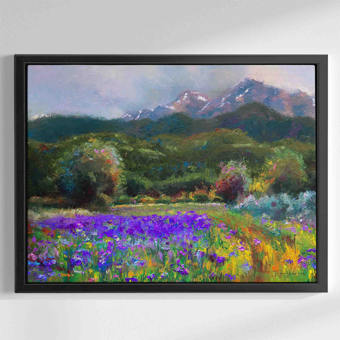 Alaska art canvas print in black floater frame of original flower landscape painting painted with a palette knife in modern impressionism style depicting wild iris flower landscape with mountains and trees in the background.