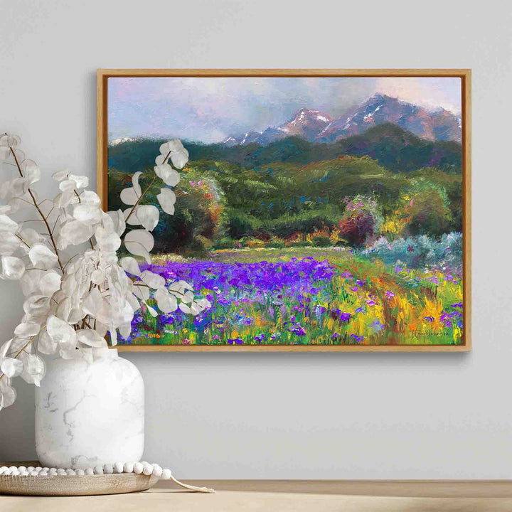 Framed Alaska art canvas print of original flower landscape painting painted with a palette knife in modern impressionism style depicting wild iris flower landscape with mountains and trees in the background displayed on a shelf with boho home decor.