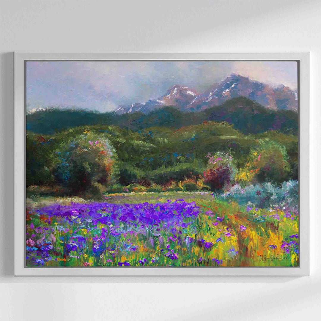 Alaska art canvas print in white floater frame of original flower landscape painting painted with a palette knife in modern impressionism style depicting wild iris flower landscape with mountains and trees in the background.