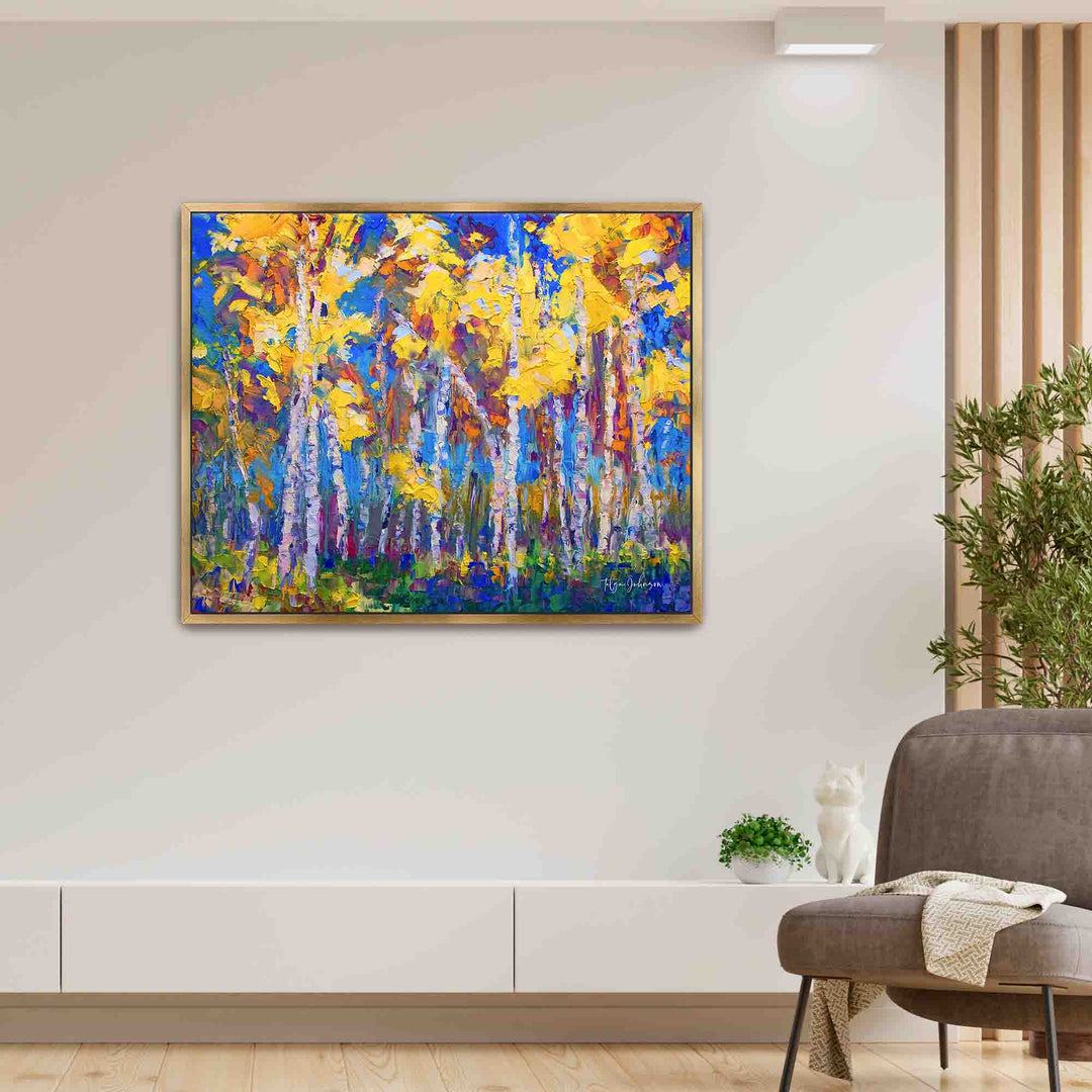 Aspen and birch tree impressionist canvas print in yellow and blue by Talya Johnson hanging in interior wall with gold floater frame