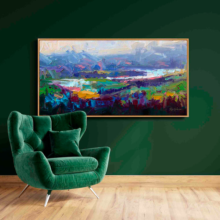 Large canvas wall art of an abstract landscape original oil impasto painting of a Pacific Northwest valley hanging on green wall with green chair.