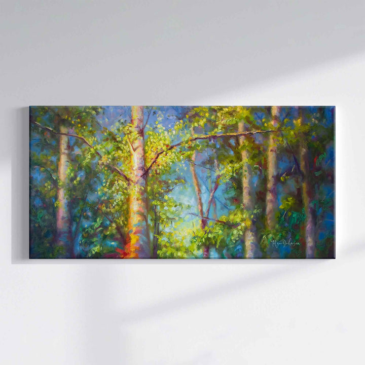 Canvas print of a painting by Talya Johnson of a forest summer scene with tall birch trees against a blue sky on a white wall.