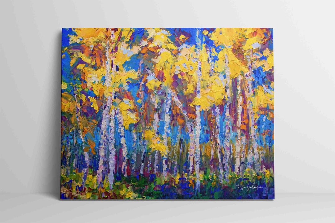 Aspen and birch tree impressionist painting on canvas print in yellow and blue by Talya Johnson leaning against interior wall