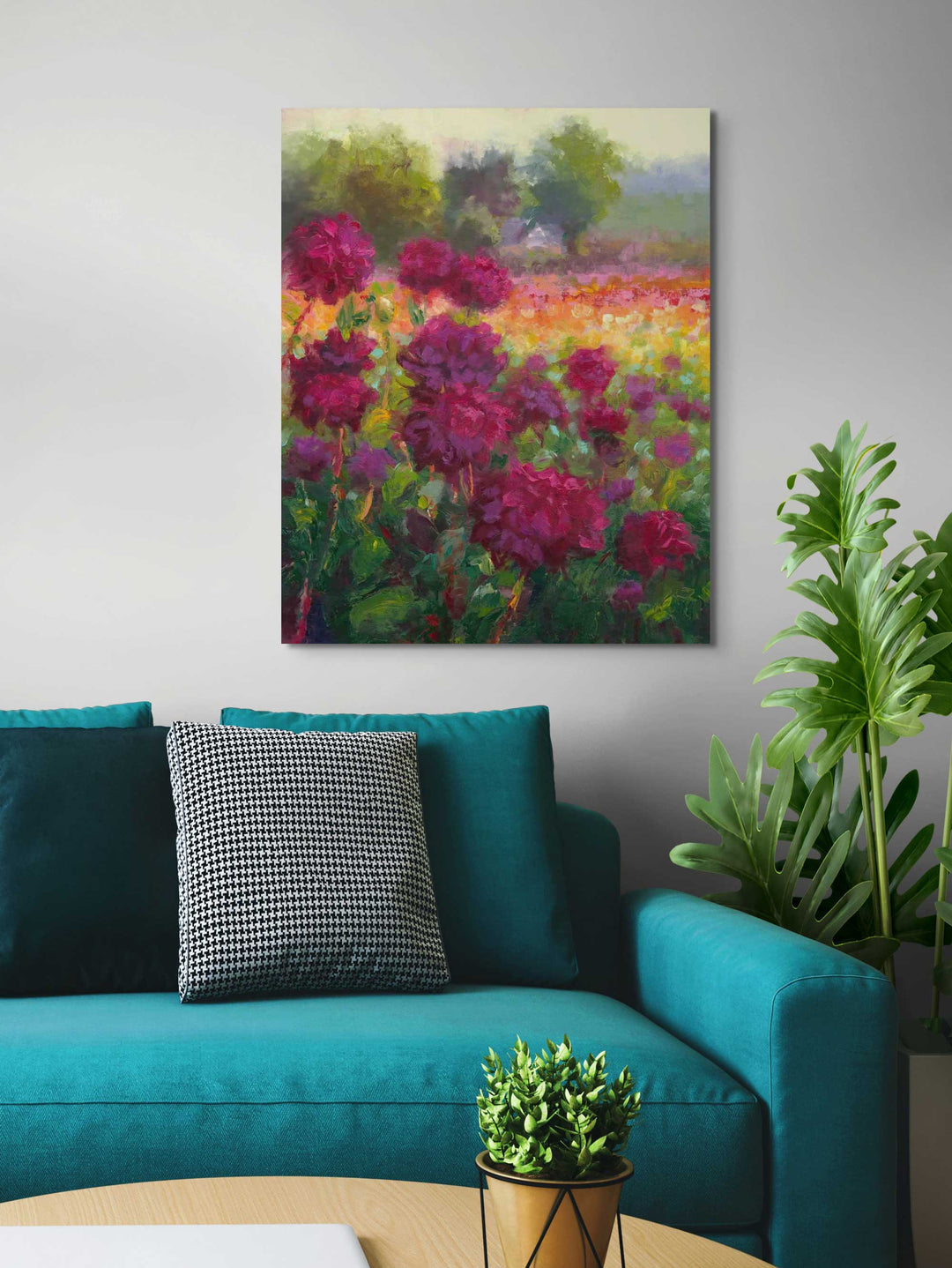 Boogie Nites, a large canvas wall art print of an impressionist oil painting landscape of Swan Island Dahlias hangs on a wall in a living room behind behind a teal sofa couch.