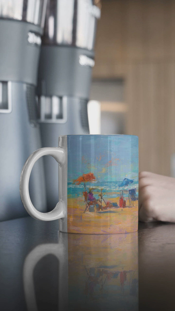 mockup video of ceramic mug feathering some beach cannon beach landscape artwork by talya johnson