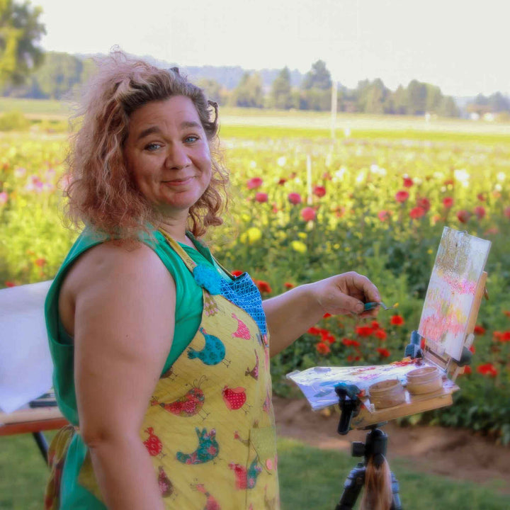 Artist Tali Johnson painting with pochade box at Swan Island Dahlias in the height of bloom season.